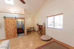 3458 N Meadow Dr, Pine, AZ 85544 - workout area with ceiling fan, light wood-style flooring, lofted ceiling, and a barn door