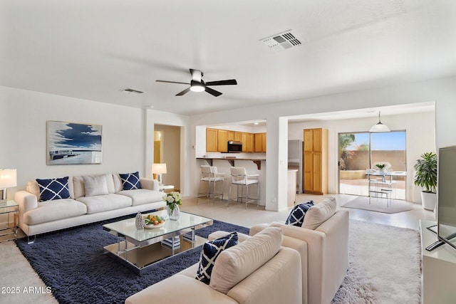 living area with a ceiling fan and visible vents