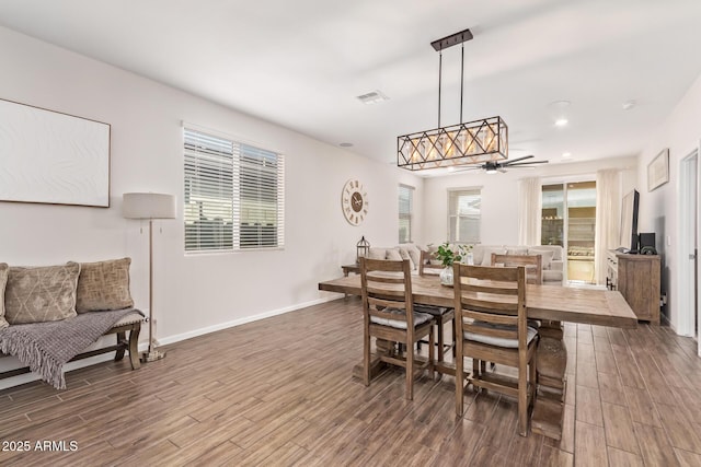 dining area with baseboards, visible vents, wood finished floors, and ceiling fan
