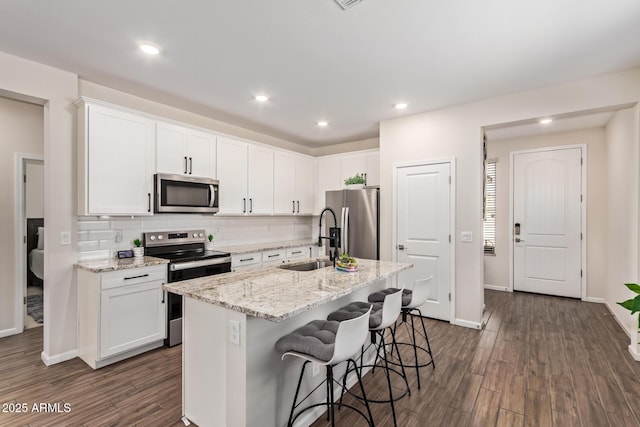 kitchen featuring dark wood-style floors, white cabinets, appliances with stainless steel finishes, and a sink