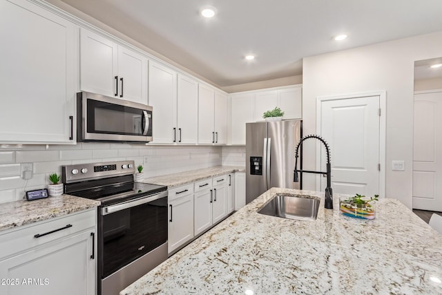 kitchen featuring a sink, white cabinets, appliances with stainless steel finishes, and tasteful backsplash