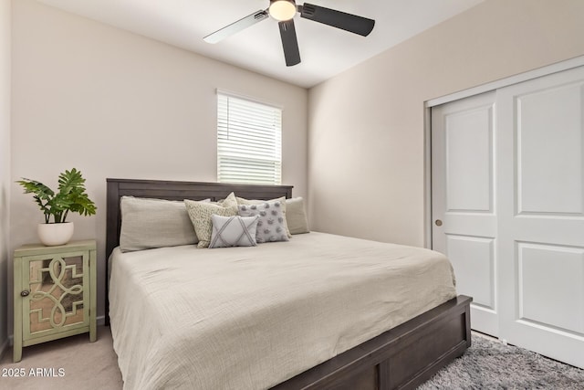 bedroom with light colored carpet, a ceiling fan, and a closet