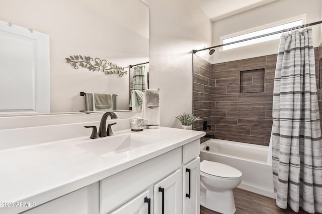 full bath with shower / bath combo, wood finished floors, toilet, and vanity