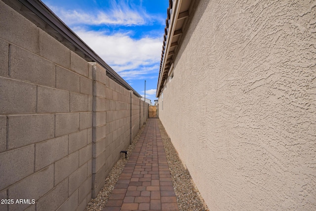 view of property exterior with stucco siding and fence