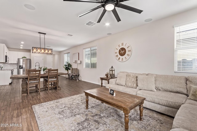living area featuring dark wood finished floors, visible vents, a ceiling fan, and recessed lighting