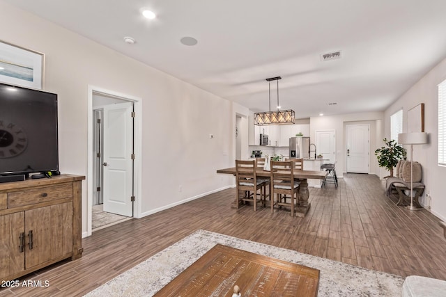 dining area with visible vents, dark wood finished floors, and baseboards