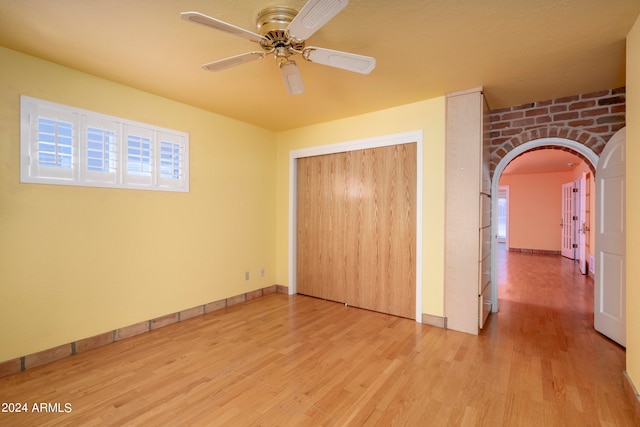 unfurnished bedroom with a closet, light hardwood / wood-style floors, and ceiling fan