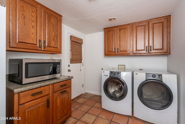 clothes washing area with a textured ceiling, light tile patterned floors, and independent washer and dryer