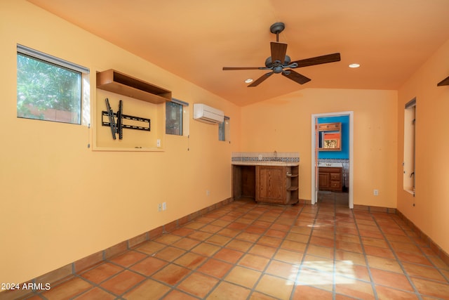 empty room with ceiling fan, lofted ceiling, light tile patterned floors, and an AC wall unit