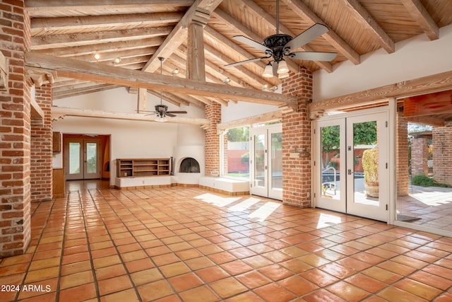 unfurnished living room featuring high vaulted ceiling, beam ceiling, ceiling fan, and french doors