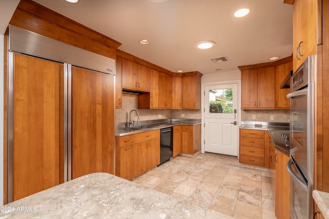 kitchen with stainless steel counters, backsplash, dishwasher, sink, and paneled fridge