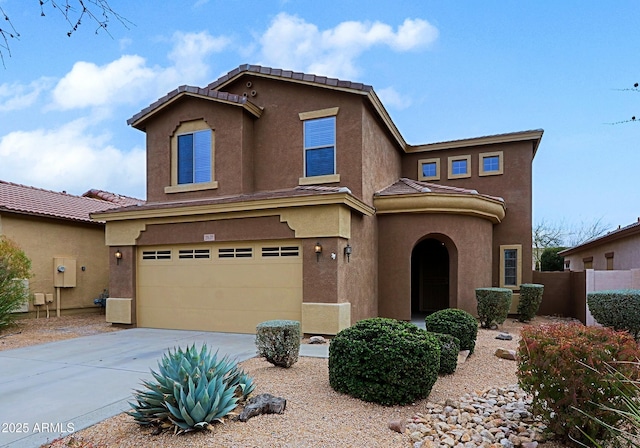 view of front of property with a garage, a tiled roof, concrete driveway, and stucco siding