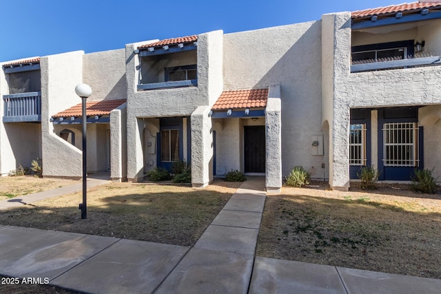 view of front of house with a balcony and a front yard