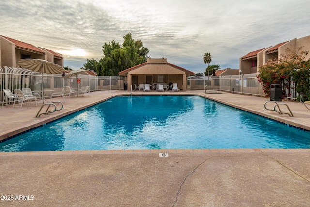 pool at dusk featuring central AC unit and a patio