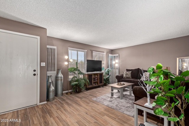 unfurnished living room featuring a textured ceiling and light hardwood / wood-style flooring