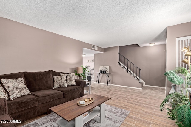 living room with light hardwood / wood-style floors and a textured ceiling