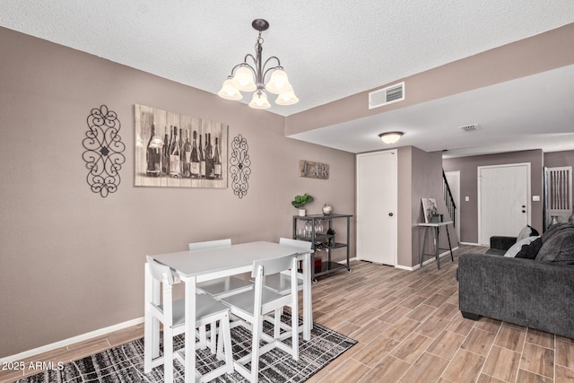 dining area featuring a chandelier and a textured ceiling