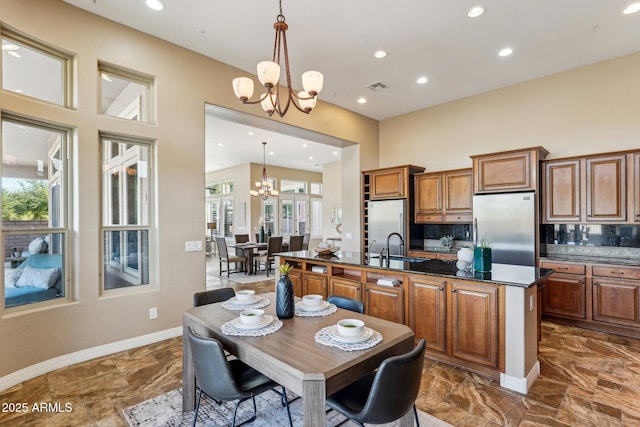 kitchen with a notable chandelier, decorative light fixtures, and stainless steel refrigerator