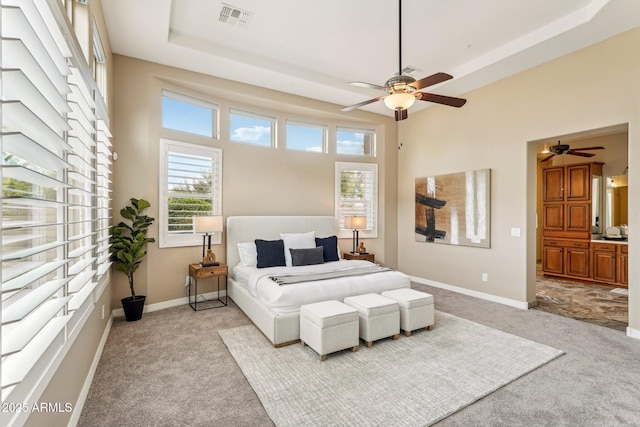 carpeted bedroom featuring a raised ceiling and ceiling fan