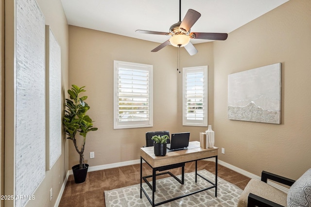 carpeted office space featuring ceiling fan