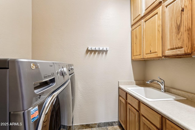 washroom featuring sink, cabinets, and independent washer and dryer