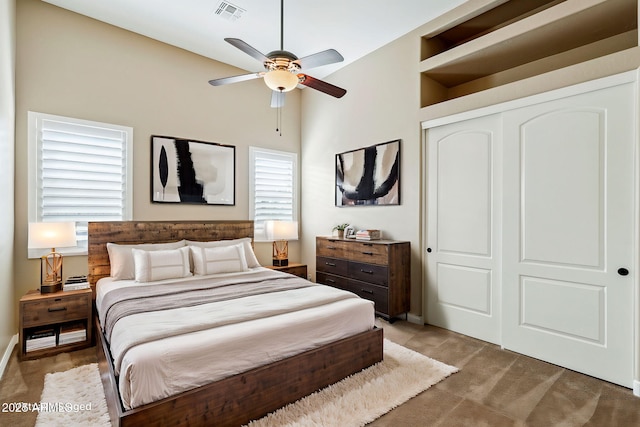 carpeted bedroom featuring multiple windows, ceiling fan, and a closet