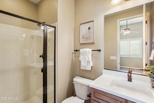 bathroom featuring walk in shower, vanity, toilet, and ceiling fan