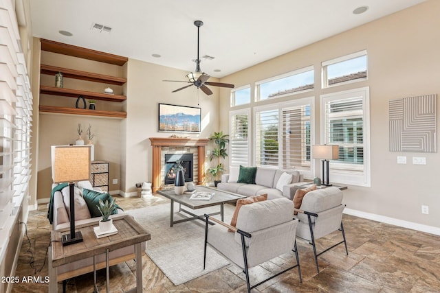 living room with a fireplace and ceiling fan