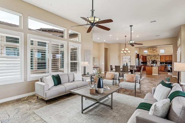 living room featuring ceiling fan with notable chandelier