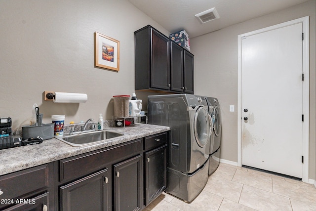 laundry area featuring cabinets, washing machine and dryer, light tile patterned floors, and sink