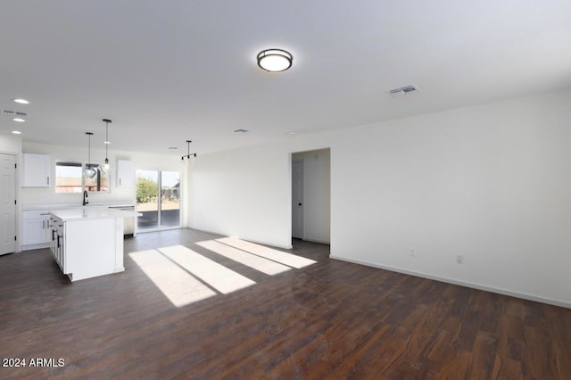 unfurnished living room featuring dark hardwood / wood-style flooring and sink