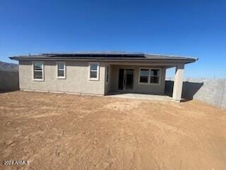 back of house featuring solar panels