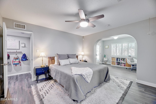 8049 N 16th Ave, Phoenix, AZ 85021 - bedroom with arched walkways, baseboards, wood finished floors, and a ceiling fan