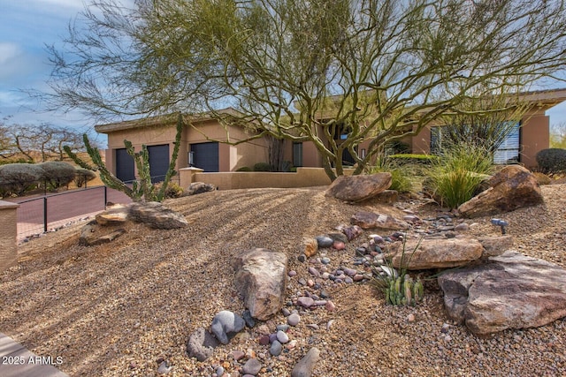 view of front of home featuring fence and stucco siding