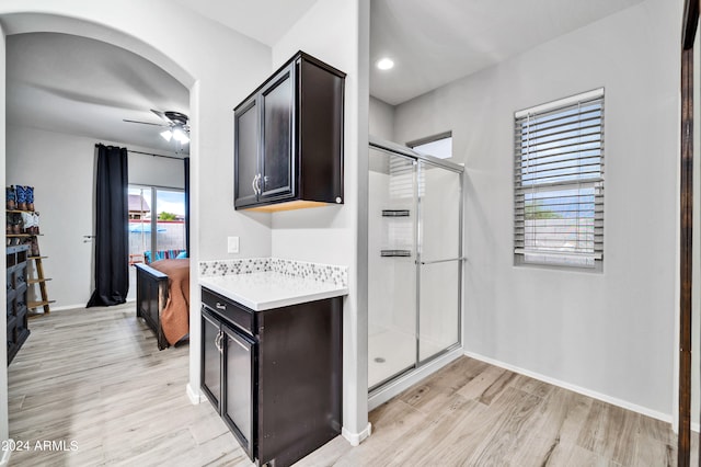 kitchen with light wood-type flooring, ceiling fan, and dark brown cabinetry