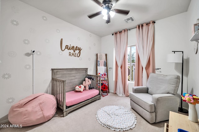 bedroom with a nursery area, carpet flooring, and ceiling fan