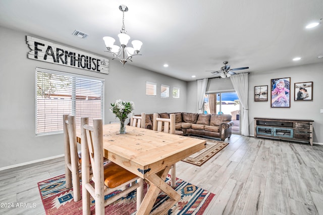 dining room featuring ceiling fan with notable chandelier, a wealth of natural light, and light hardwood / wood-style floors