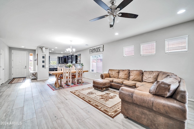 living room featuring light hardwood / wood-style flooring and ceiling fan with notable chandelier