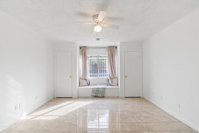 empty room featuring a textured ceiling and ceiling fan