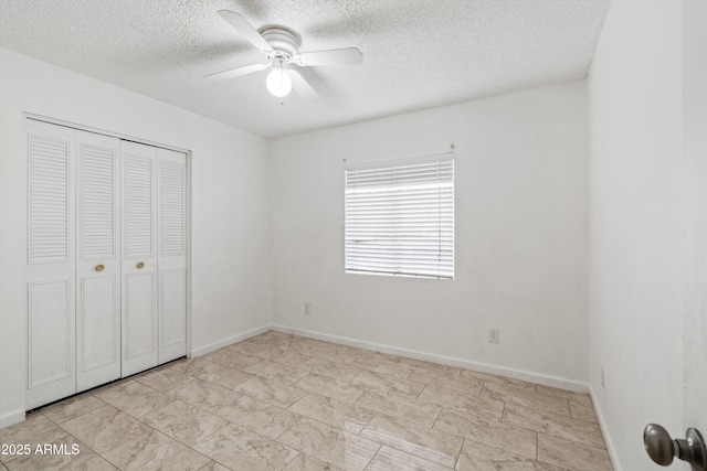 unfurnished bedroom with ceiling fan, a textured ceiling, and a closet