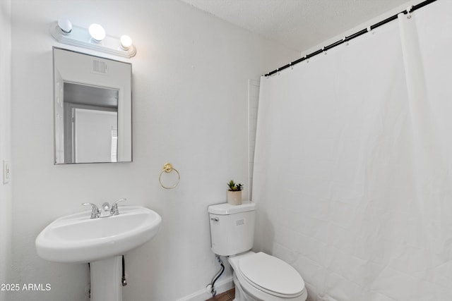 bathroom featuring a textured ceiling and toilet