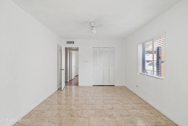 unfurnished bedroom featuring ceiling fan and a closet