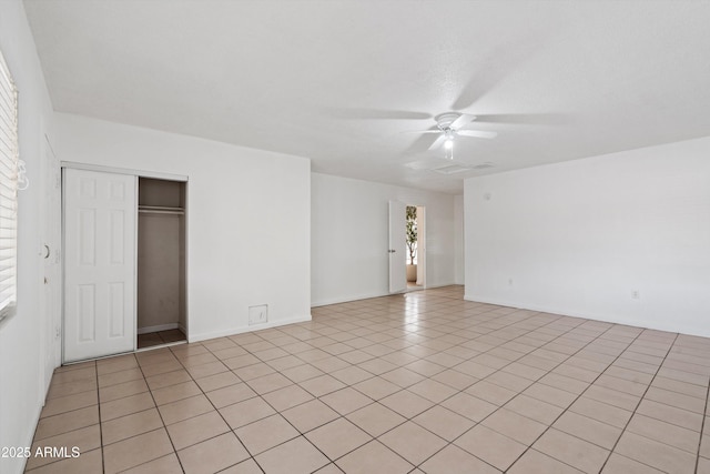 unfurnished bedroom featuring ceiling fan, a closet, and light tile patterned floors