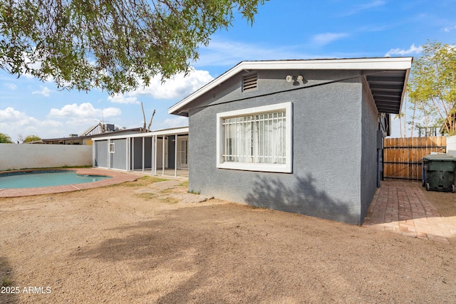 back of house featuring a fenced in pool and a patio