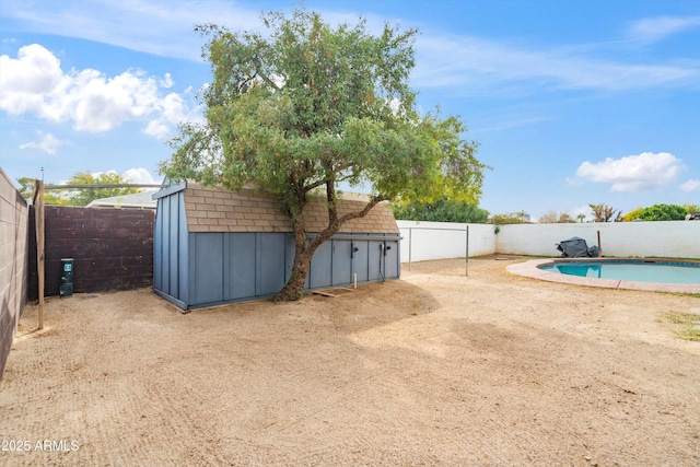 view of yard featuring a fenced in pool and a storage shed