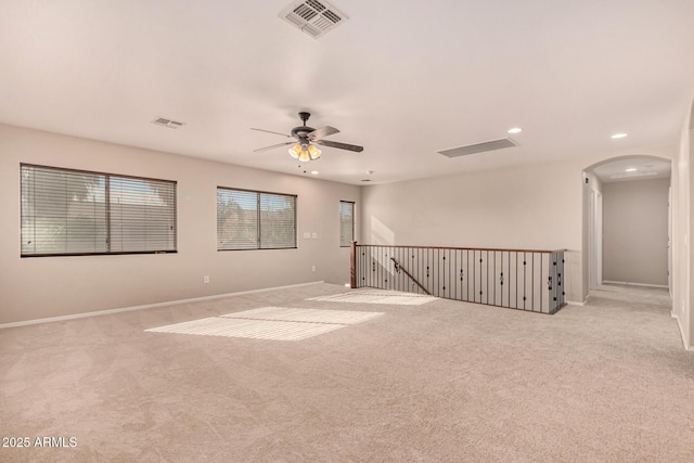 spare room with ceiling fan and light carpet