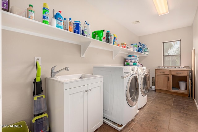 washroom featuring cabinets, sink, and washing machine and dryer