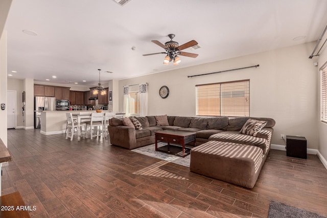 living room featuring ceiling fan and dark wood-type flooring