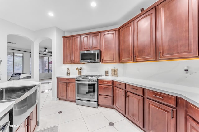 kitchen featuring sink, stainless steel appliances, ceiling fan, and light tile patterned flooring