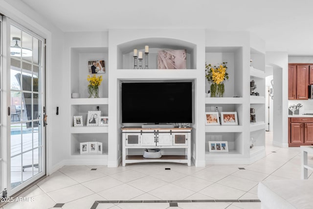 living room with a healthy amount of sunlight, light tile patterned floors, and built in shelves